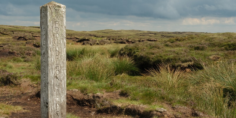 view of moorland with marker post in foreground